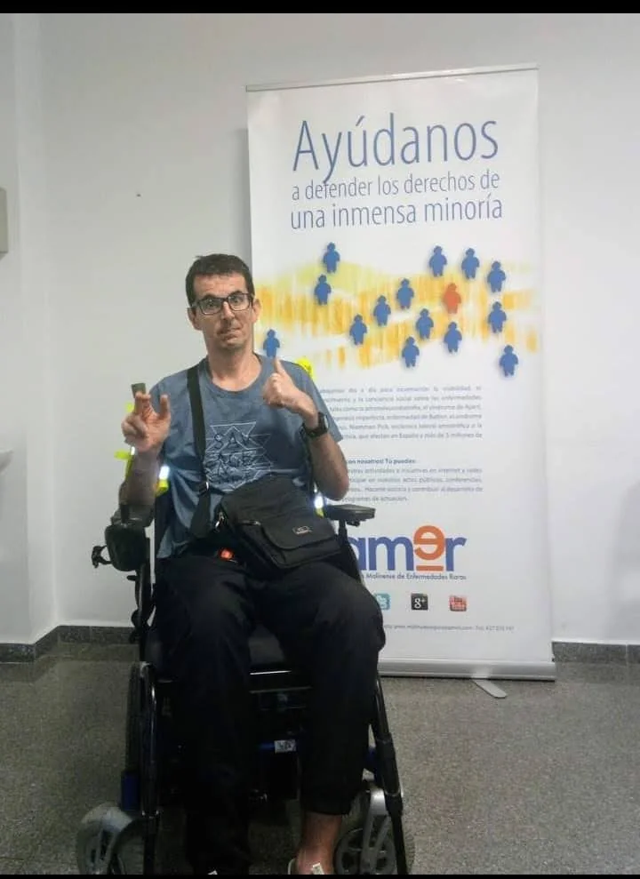 Daniel Martínez Riquelme junto a un cartel de AMER